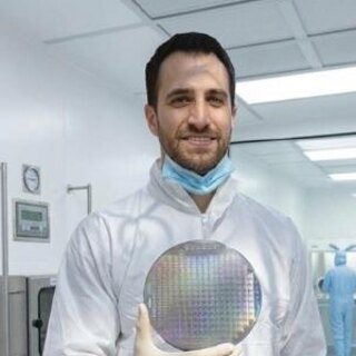 Dr. Javier Cruz in the clean room holding a wafer of emitters
